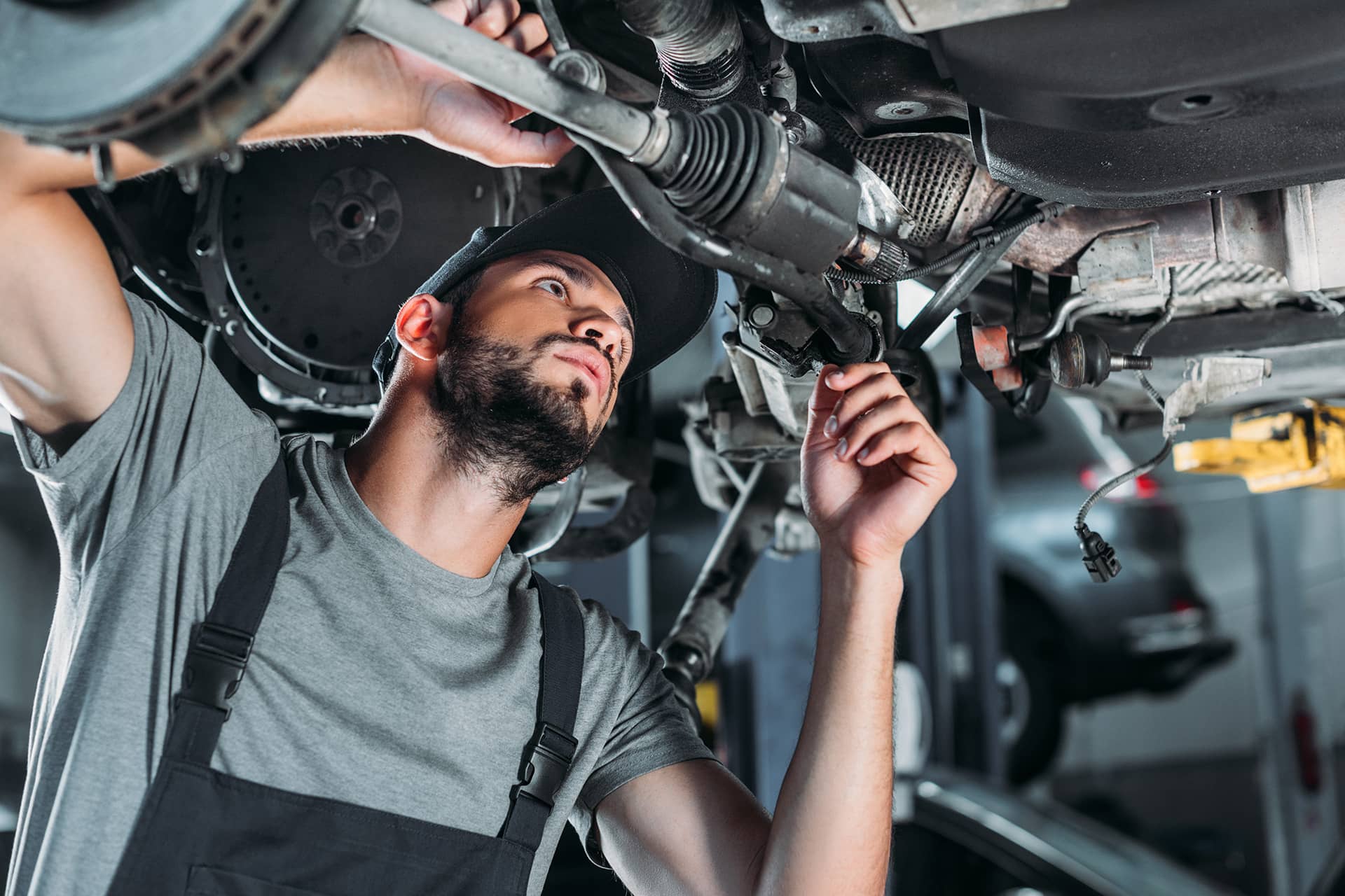 mechanic working on the underside of a car lifted up